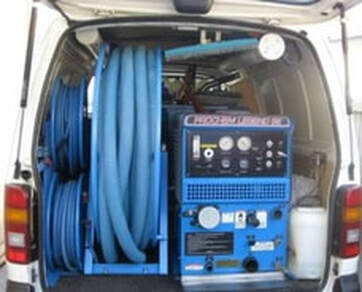 view of the inside of a carpet cleaning service van from the back doors
